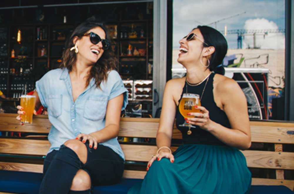 Two Women Enjoying A Beer